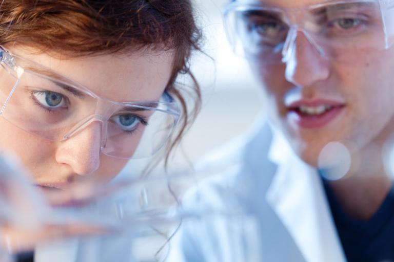 Chemistry laboratory. Teacher and a young woman working together in a biology, chemistry research laboratory. Customized learning in a small school