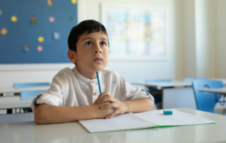 Male ADHD student looking at a ceiling in a classroom.