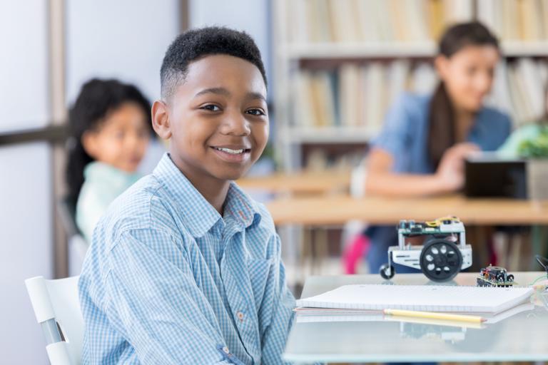 Handsome junior high student enjoying building a robot in a private school class.