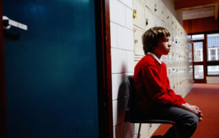 Sad school boy in a corridor