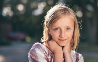 young blonde teenage girl posing outside