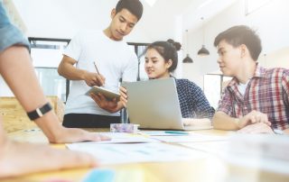 Young teenage students working together on student devices