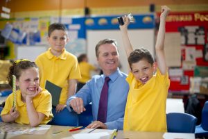 schoolboy receives his trophy from his teacher. Competition-based learning