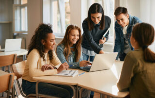 teacher-assisting-her-students-during-computer-class-in-a-classroom-achievement-gap-concept