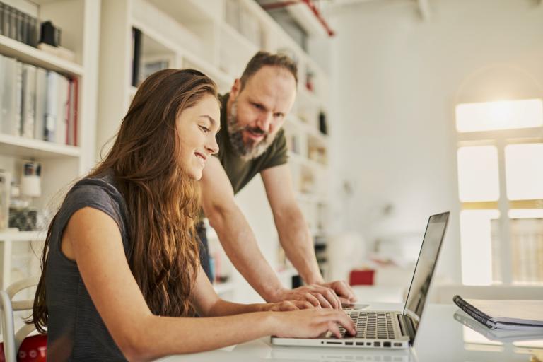 Father helping teenager with her homework helping her overcome end-of-year academic burnout