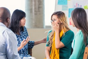 Hispanic teenage girl is emotional as Asian female teacher counsels her about Hurricane Harvey aftermath