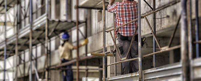 Back view of female and male worker on scaffolding.