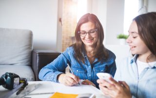 Photo of mother and daughter planning at home. Parent intervention concept