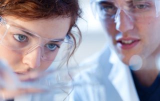 Chemistry laboratory. Teacher and a young woman working together in a biology, chemistry research laboratory. Customized learning in a small school