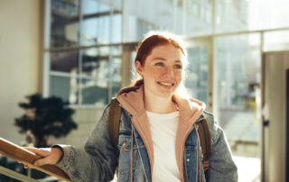 Female student standing in the hallway during a campus tour.