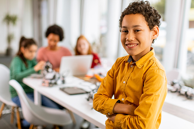 A young student standing in a classroom. He is part of a gifted and talented program.