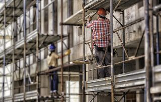 Back view of female and male worker on scaffolding.