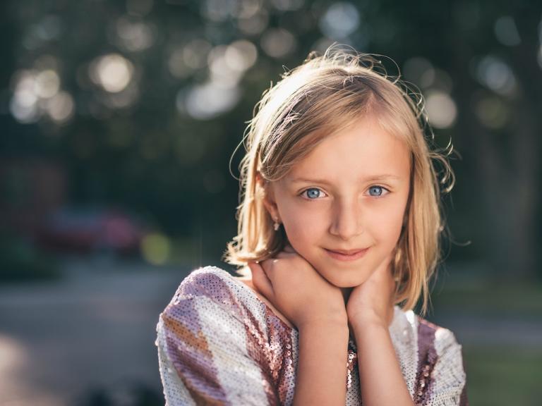 young blonde teenage girl posing outside