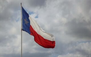 The Texas state flag blowing in the wind relating to the passing of the school voucher bill.