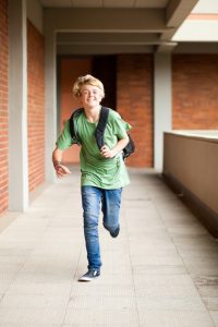 male middle school student running running late for school