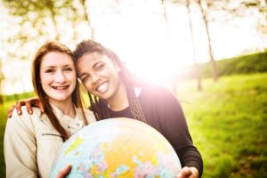 international students outside smiling with globe