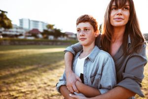 teenager embraced with mom