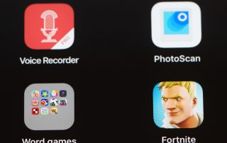 Multiple mobile apps are visible on an Apple iPad screen including the popular video games Fortnite and Angry Birds 2. Other apps include Starbucks and groups of Word Games and Productivity apps.