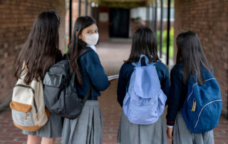 A middle school girl walking with her friends on the first day.