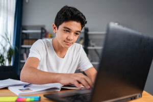 teenage-boy-accessing-internet-with-laptop