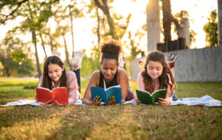 group-of-students-reading-books-in-the-school-park-summer-slide-concept