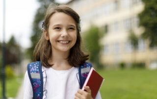 Female middle schooler happily smiling and enjoying her day at school