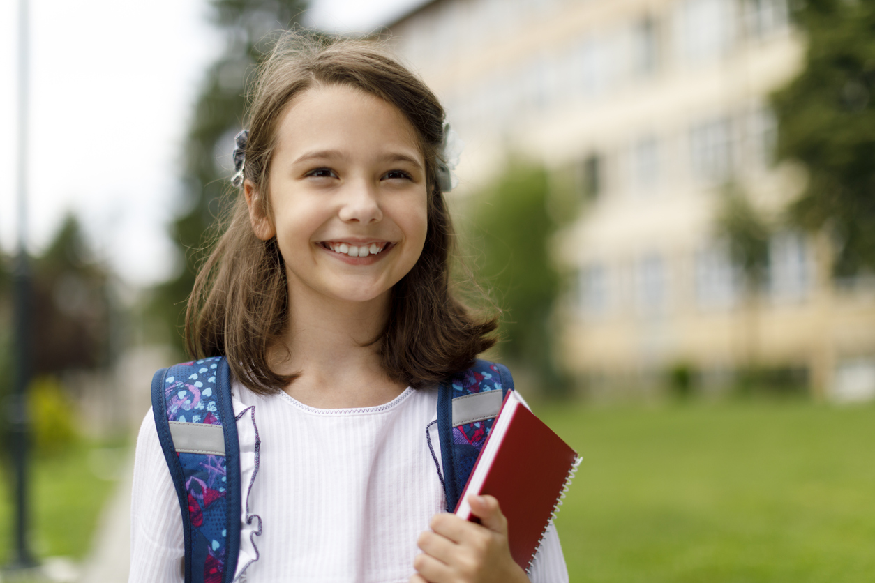 Female middle schooler happily smiling and enjoying her day at school