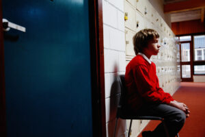 Sad school boy in a corridor