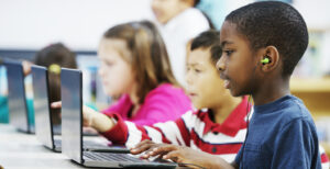 Group of elementary students in the computer lab using laptops.