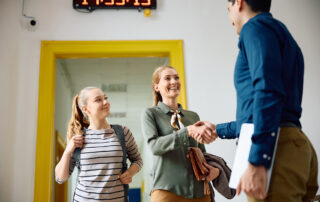 Is private school worth it? A student and parent greeting a private school admissions officer.