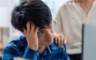 A student on a computer at home looking at their grades realizing they're struggling in school.